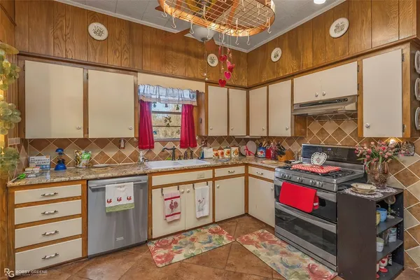 a kitchen with stainless steel appliances granite countertop a sink stove and cabinets