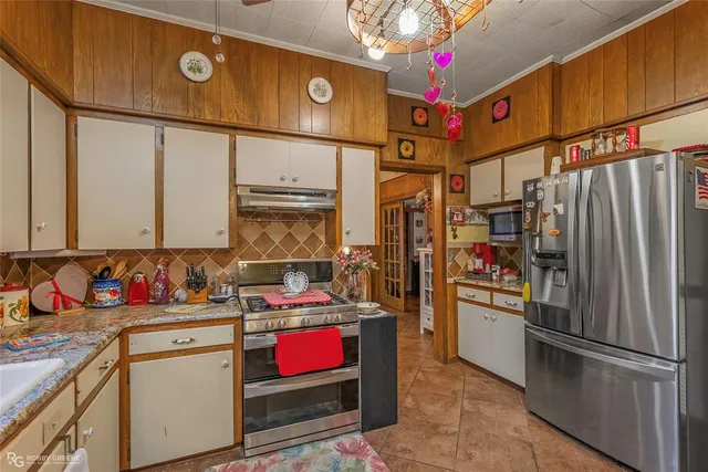 a kitchen with stainless steel appliances granite countertop a refrigerator and a stove