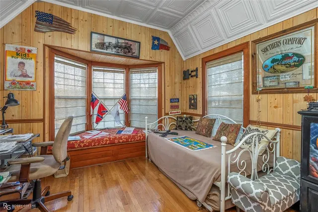 a bedroom with furniture and a large window