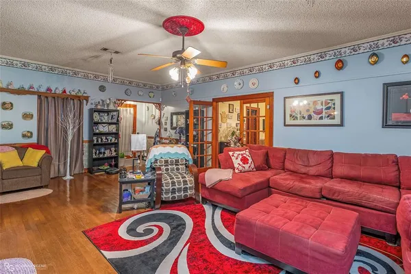a living room with furniture a chandelier and a flat screen tv