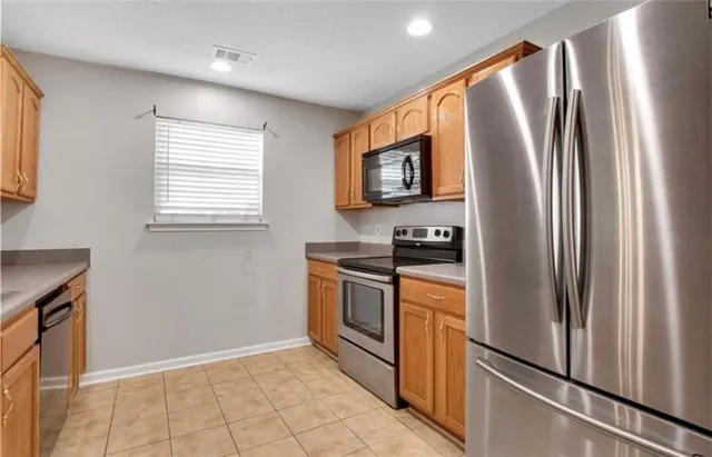 a kitchen with stainless steel appliances granite countertop a refrigerator and a sink