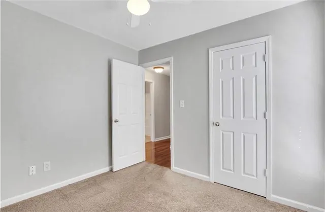 an empty room with a window and a ceiling fan