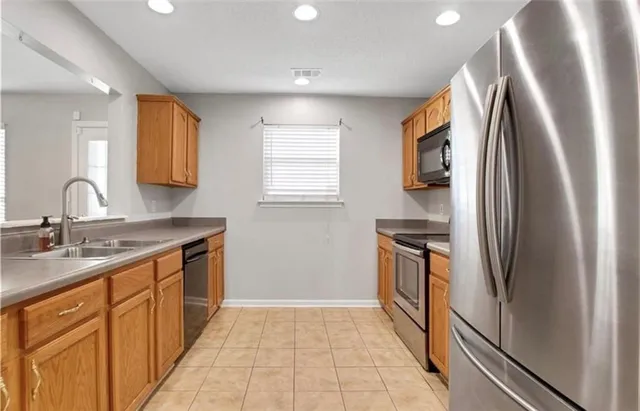 a kitchen with stainless steel appliances granite countertop a refrigerator and a sink