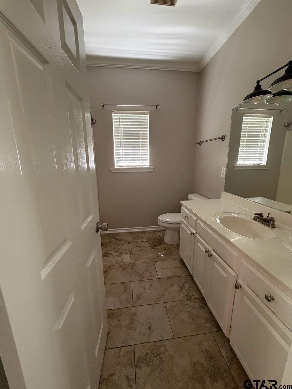3204 Pebblebrook Circle Tyler, TX 75707 - Photo 8 of 18 a bathroom with a sink a toilet and mirror