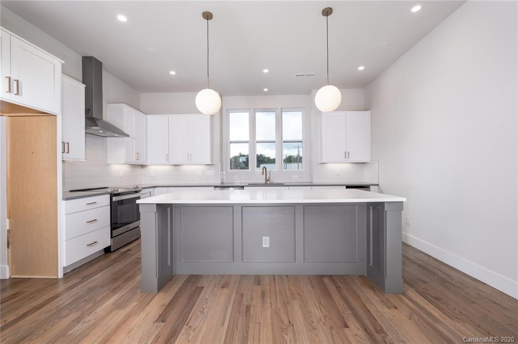 2531 Irwin Stream Road, Unit 20 Charlotte, NC 28208 - Photo 6 of 18 a kitchen with kitchen island white cabinets and stainless steel appliances