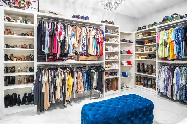 a view of walk in closet with clothes and shoes