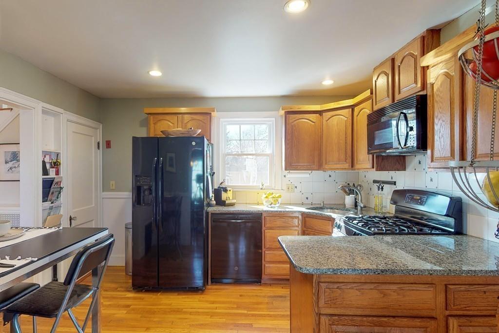 1 Mitchell Road Marblehead, MA 01945 - Photo 12 of 22 a kitchen with granite countertop wooden cabinets a refrigerator and a sink