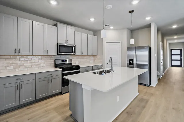 a kitchen with kitchen island white cabinets and stainless steel appliances