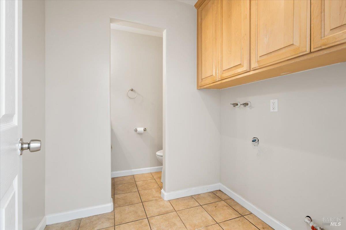 303 Algiers Court Santa Rosa, CA 95409 - Photo 13 of 27 Downstairs laundry room room with upper cabinets and leads to half bath.