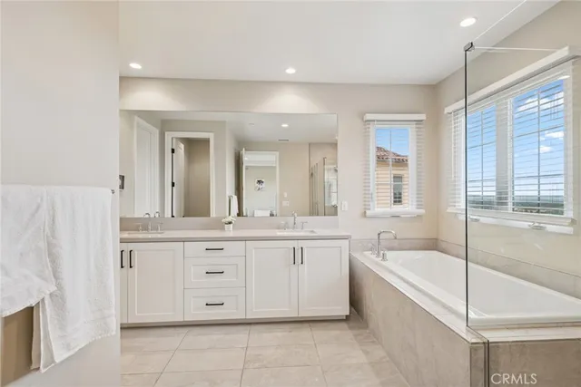 a spacious bathroom with a granite countertop tub sink and mirror