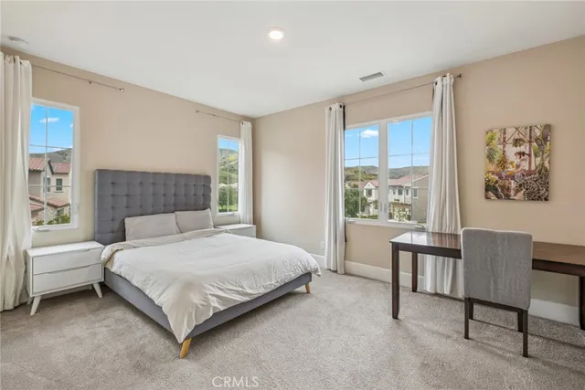 a bedroom with a bed chair and a window