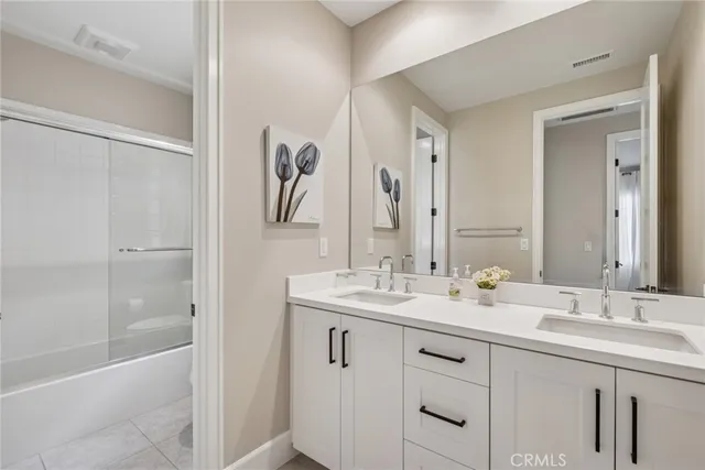 a bathroom with a double vanity sink mirror double and a bathtub