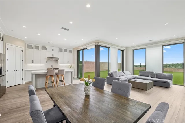 a living room with furniture dining table and a large window