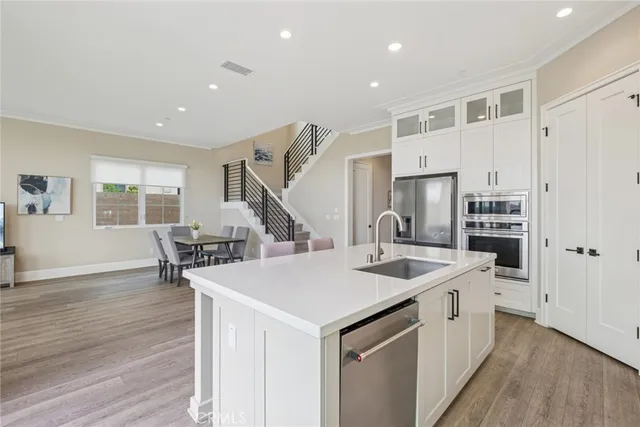 a kitchen that has a sink a stove and wooden floor