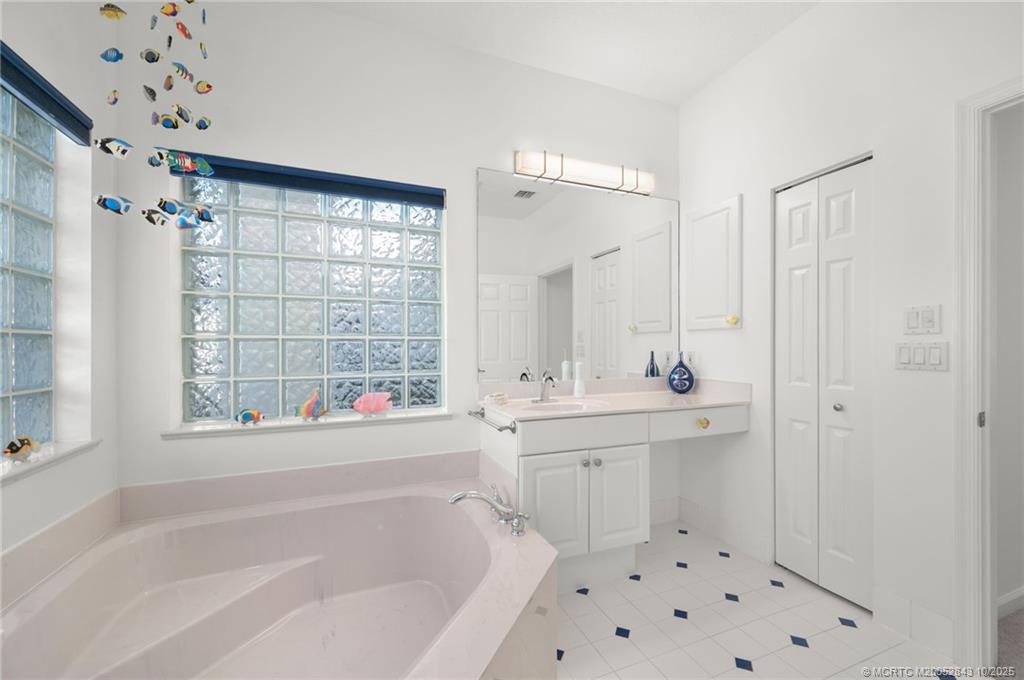 2227 Southeast Stonehaven Road Port St. Lucie, FL 34952 - Photo 11 of 35 a bathroom with a bathtub sink and mirror