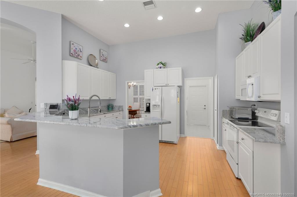 2227 Southeast Stonehaven Road Port St. Lucie, FL 34952 - Photo 18 of 35 a kitchen with stainless steel appliances a sink stove and cabinets