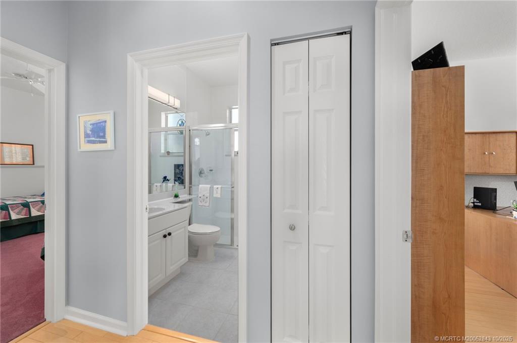 2227 Southeast Stonehaven Road Port St. Lucie, FL 34952 - Photo 24 of 35 a bathroom with a glass door shower a sink and a mirror