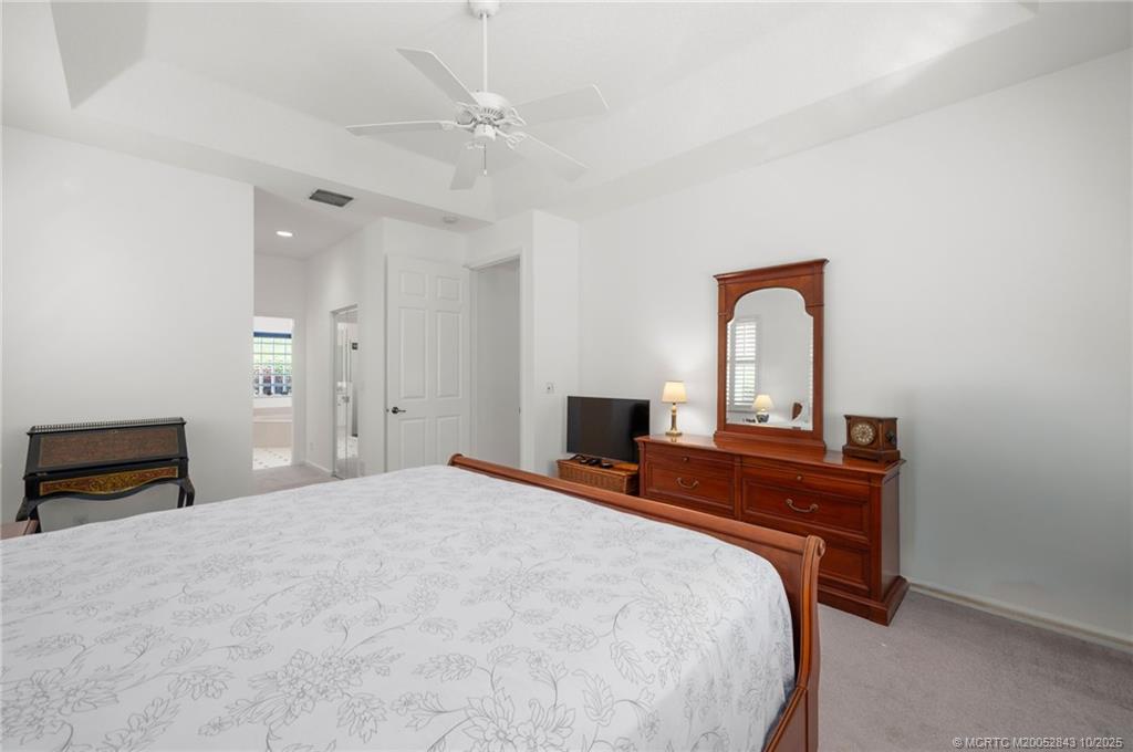 2227 Southeast Stonehaven Road Port St. Lucie, FL 34952 - Photo 7 of 35 a bedroom with a bed and a potted plant on dresser