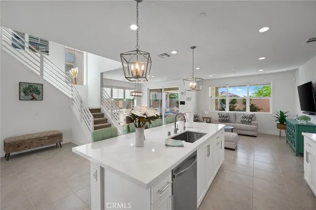 a kitchen with kitchen island granite countertop a sink a counter top space stainless steel appliances and cabinets