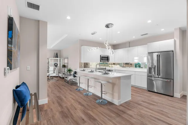 a kitchen with stainless steel appliances kitchen island hardwood floor sink and stove