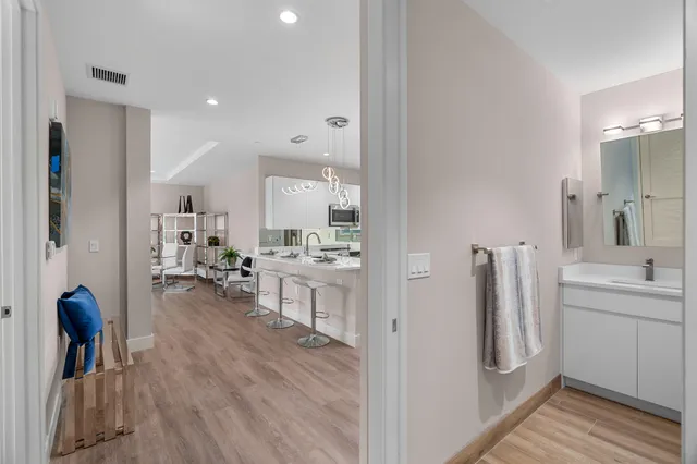 a kitchen with stainless steel appliances granite countertop a refrigerator a sink a stove a microwave and a refrigerator