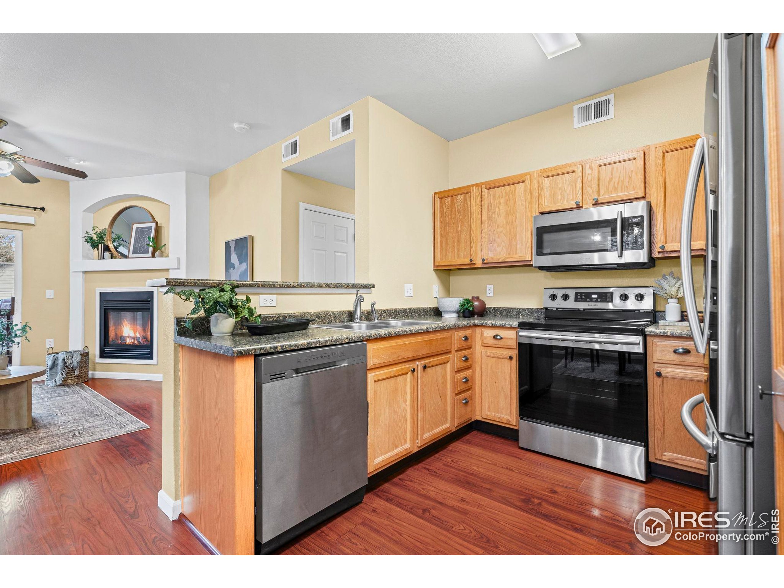 3002 West Elizabeth Street, Unit D Fort Collins, CO 80521 - Photo 11 of 23 a kitchen with granite countertop a stove a sink and a microwave