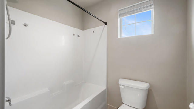 1223 East 1775 North Payson, UT 84651 - Photo 34 of 45 Bathroom featuring a white bathtub/shower combination with an integrated shelving unit, a white toilet, and a window with blinds