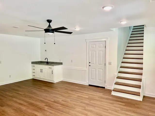 a view of a kitchen with wooden floor and a ceiling fan