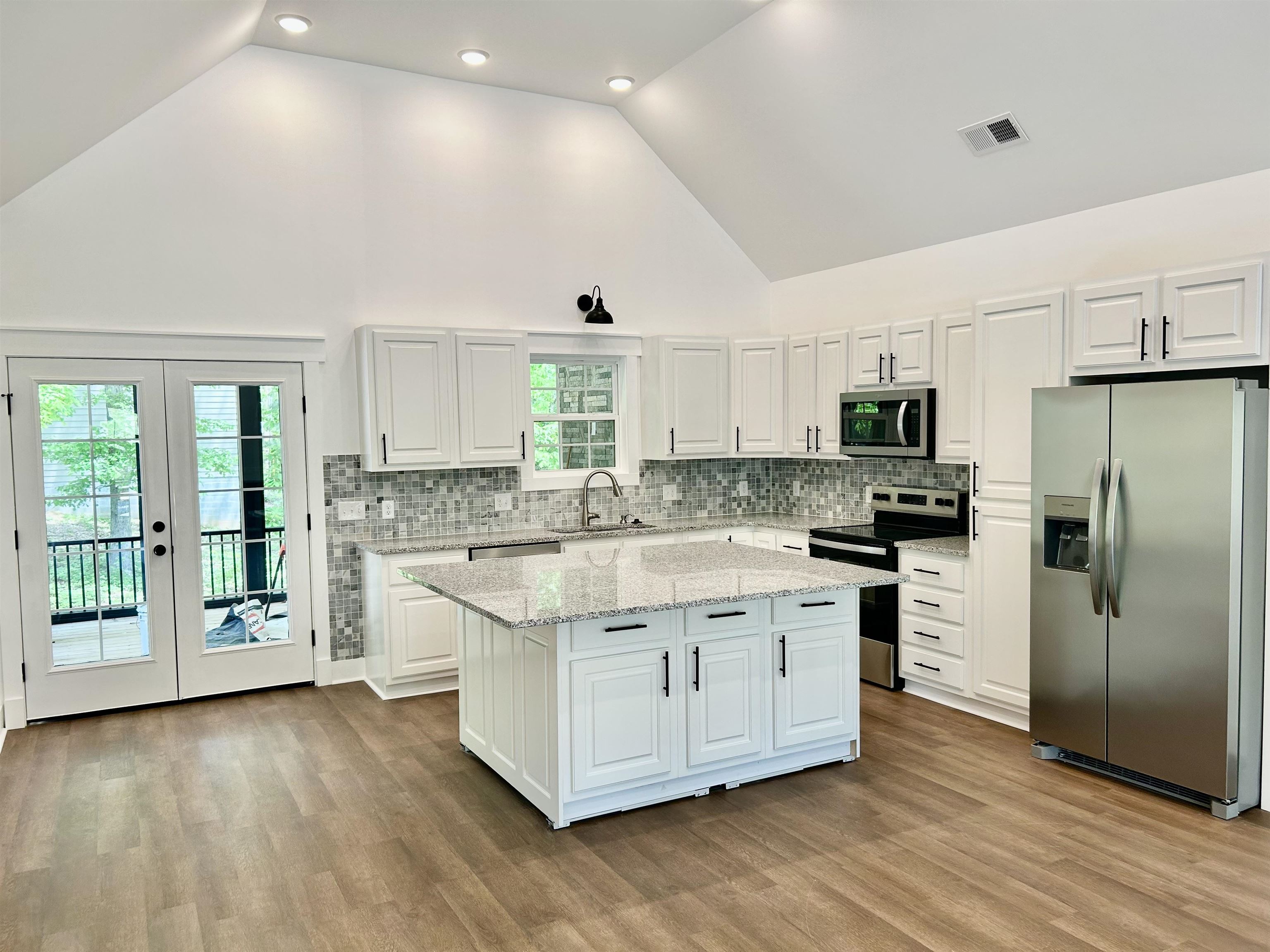 35 Grapevine Cove Counce, TN 38326 - Photo 5 of 25 a large kitchen with stainless steel appliances a large counter top a stove a refrigerator cabinets and a wooden floor