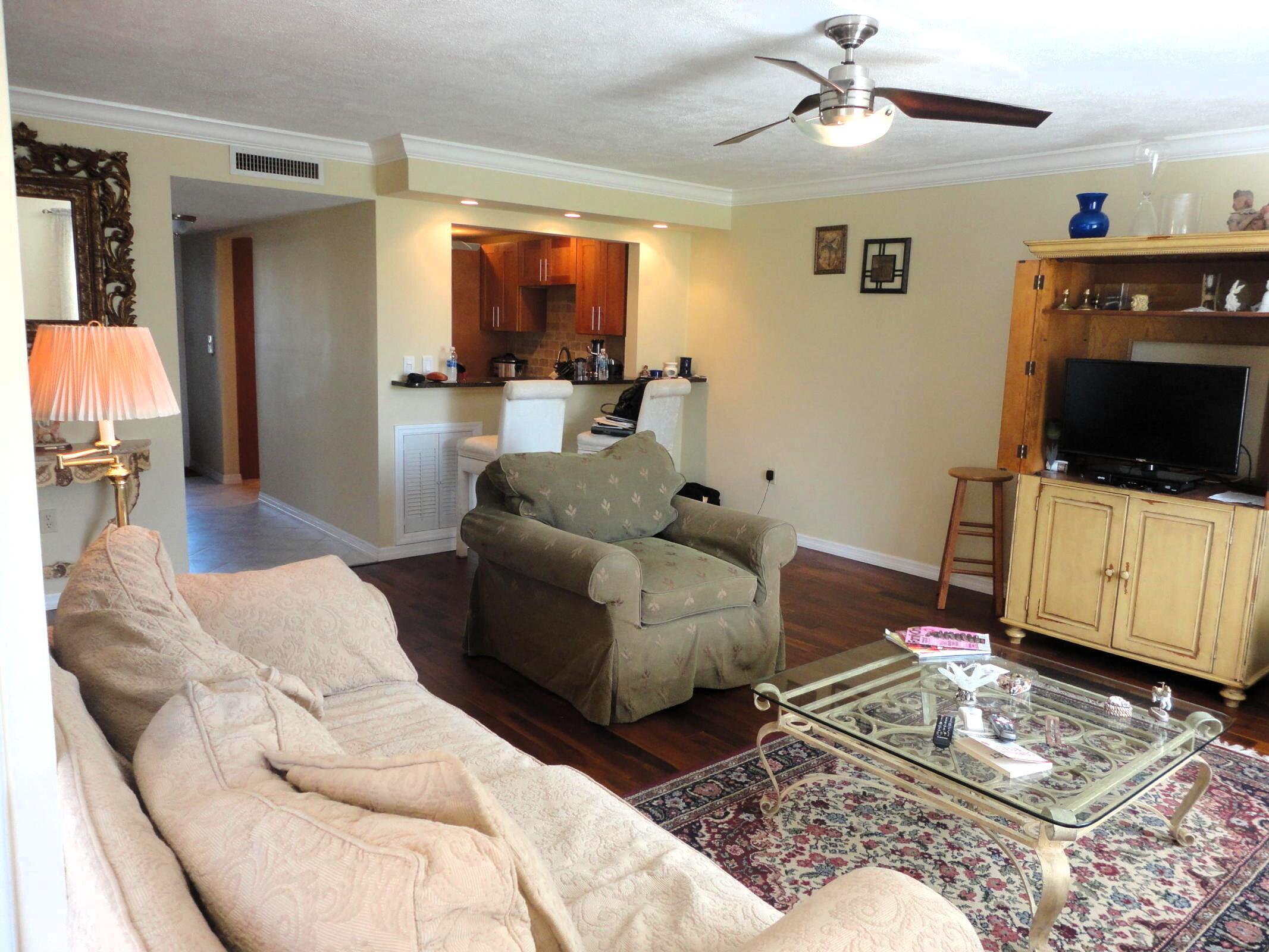 5433 Southeast Miles Grant Road, Unit 104 Stuart, FL 34997 - Photo 4 of 16 a living room with furniture and a flat screen tv