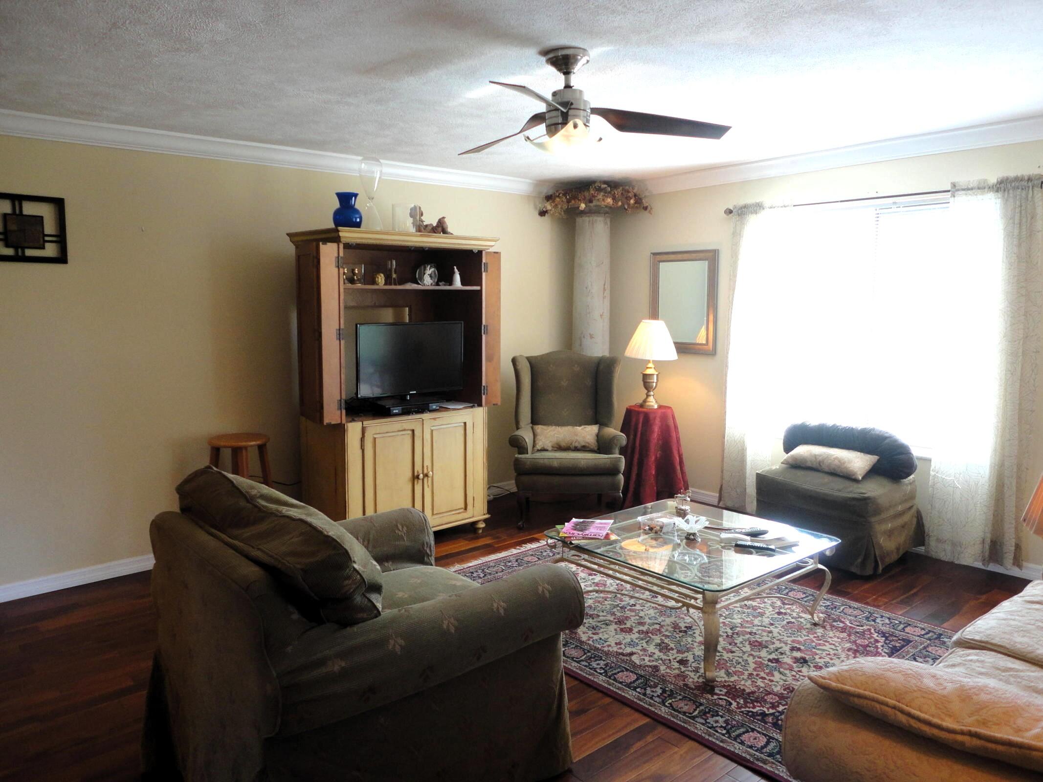 5433 Southeast Miles Grant Road, Unit 104 Stuart, FL 34997 - Photo 6 of 16 a living room with furniture and a flat screen tv
