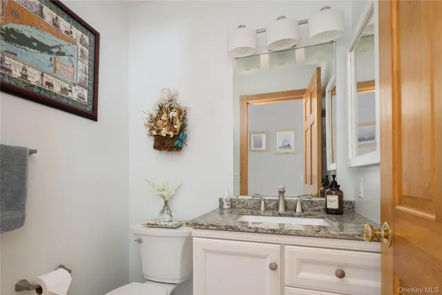 a bathroom with a granite countertop sink mirror and toilet