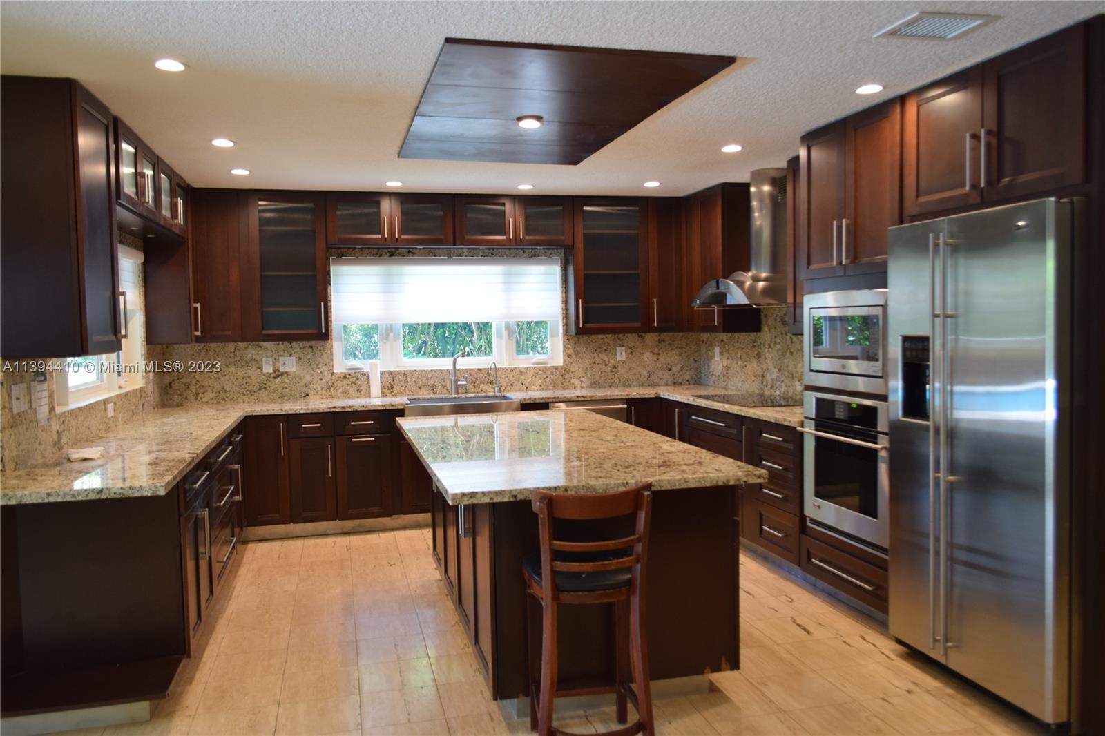 7115 Southwest 69th Court Miami, FL 33143 - Photo 18 of 58 a kitchen with stainless steel appliances granite countertop a refrigerator a sink and a stove