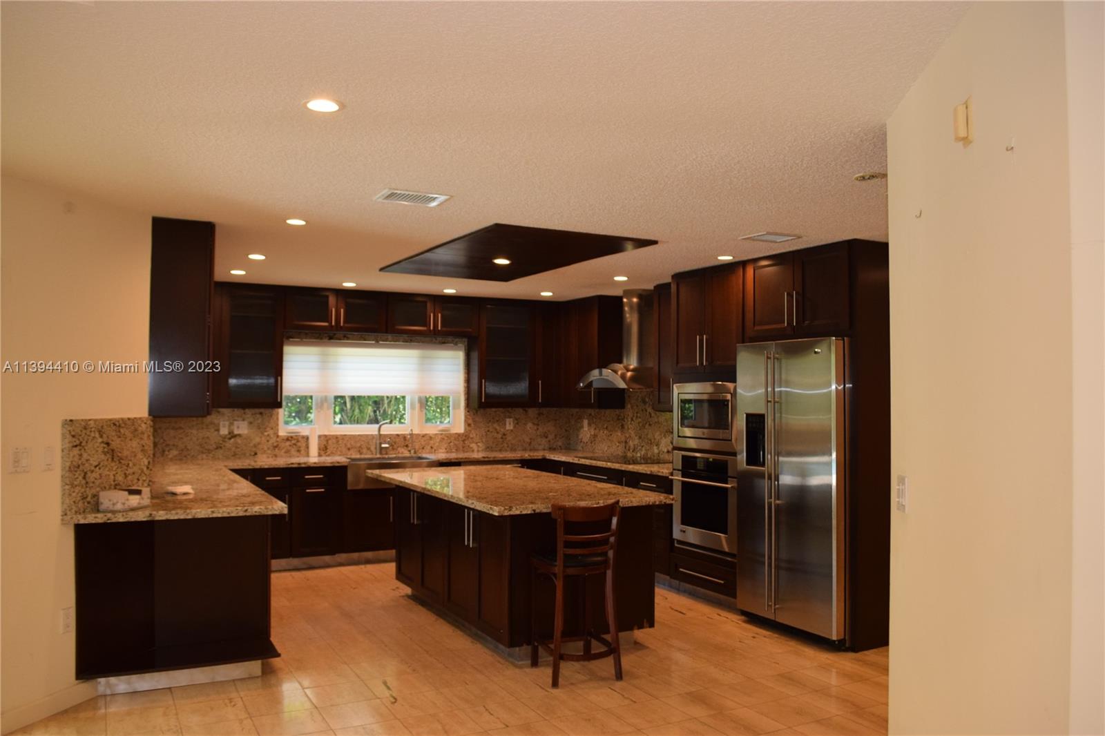 7115 Southwest 69th Court Miami, FL 33143 - Photo 2 of 58 a kitchen with stainless steel appliances granite countertop a sink and a refrigerator