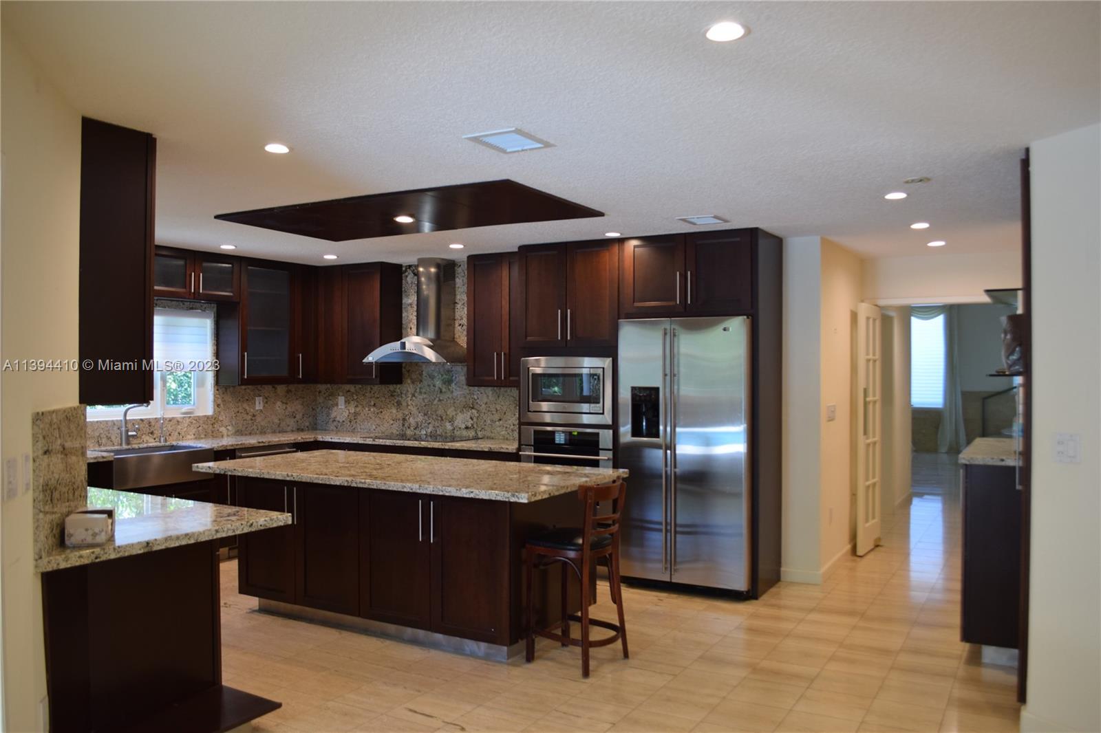 7115 Southwest 69th Court Miami, FL 33143 - Photo 50 of 58 a kitchen with stainless steel appliances granite countertop a sink refrigerator and cabinets