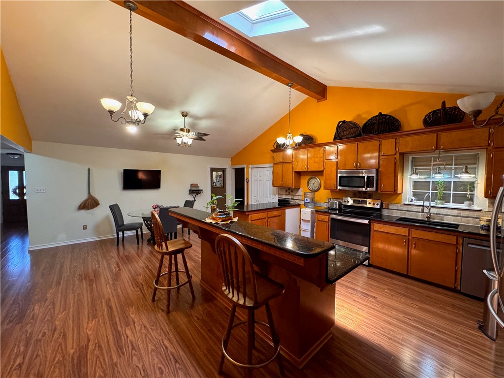 296 County Road 1601 Alice, TX 78332 - Photo 14 of 38 a kitchen with stainless steel appliances granite countertop a stove a refrigerator a kitchen island a dining table and chairs with wooden floor