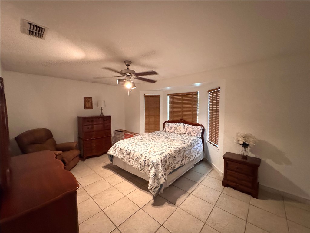 296 County Road 1601 Alice, TX 78332 - Photo 20 of 38 a bedroom with a bed and a lamp on dresser