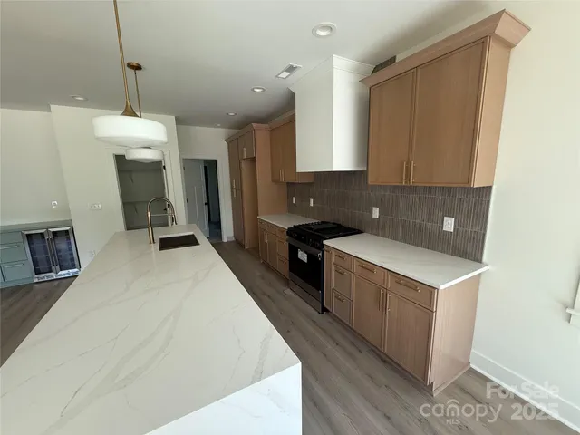 a kitchen with a refrigerator a sink dishwasher and a stove with wooden floor