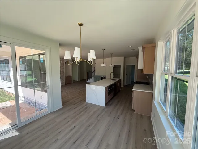 a kitchen with a wooden floor and a large window