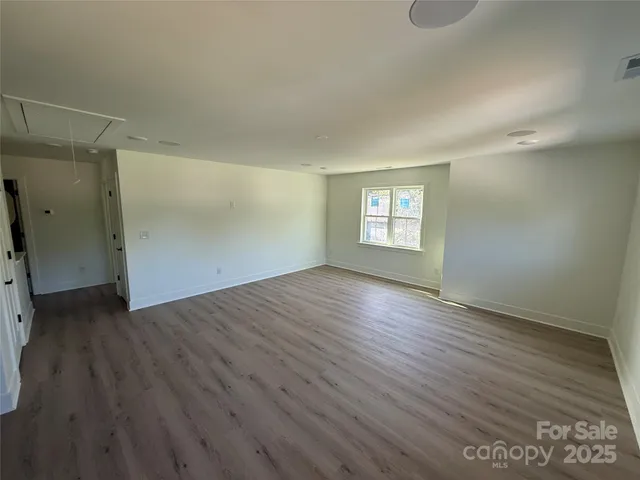 an empty room with wooden floor and window