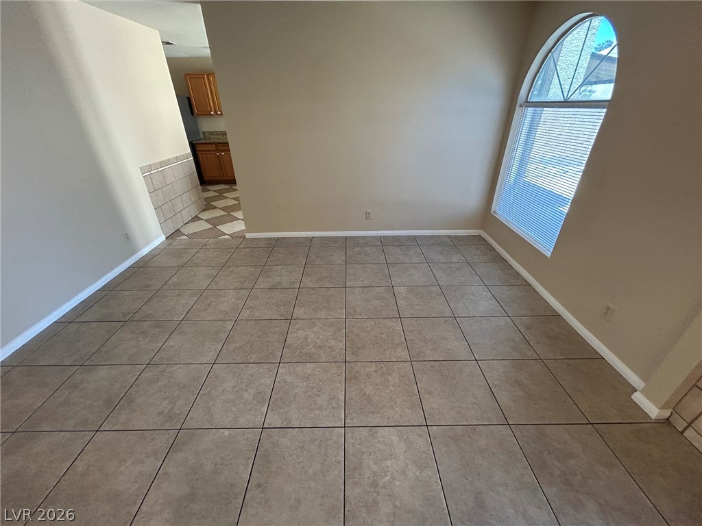 2806 Rungsted Street Las Vegas, NV 89142 - Photo 7 of 18 Natural light filters through an arched window, illuminating the tiled flooring throughout this flexible living space.