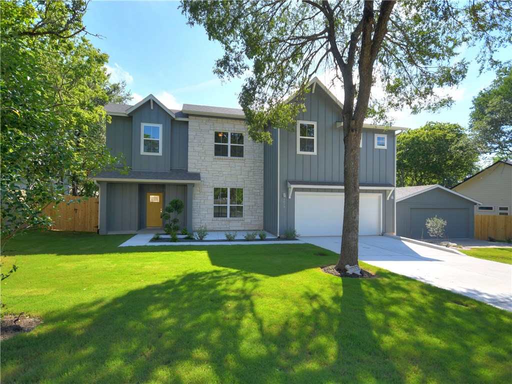 a view of a yard in front of house with a large tree