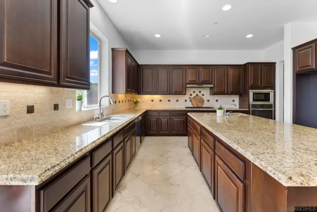 a kitchen with stainless steel appliances granite countertop a sink stove and cabinets