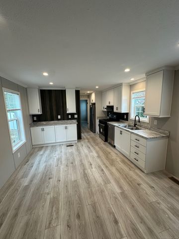a large kitchen with cabinets wooden floor and stainless steel appliances