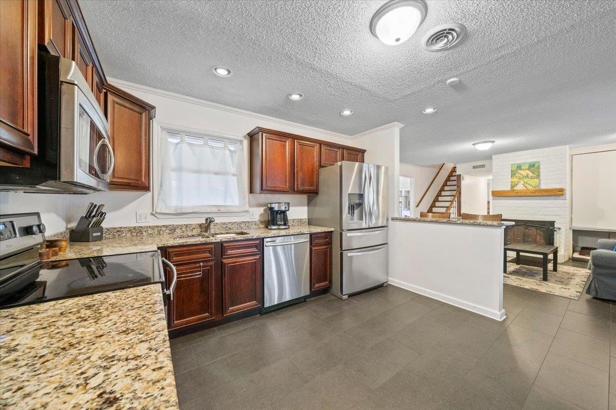 436 Cardinal Drive Collierville, TN 38017 - Photo 12 of 32 a kitchen with granite countertop a sink stainless steel appliances and counter space