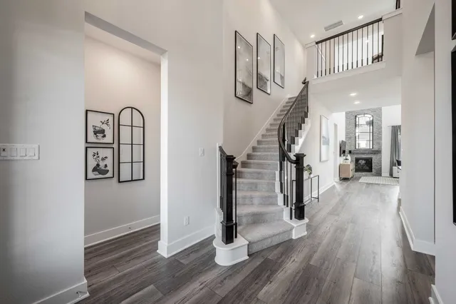 a view of a hallway with wooden floor and staircase