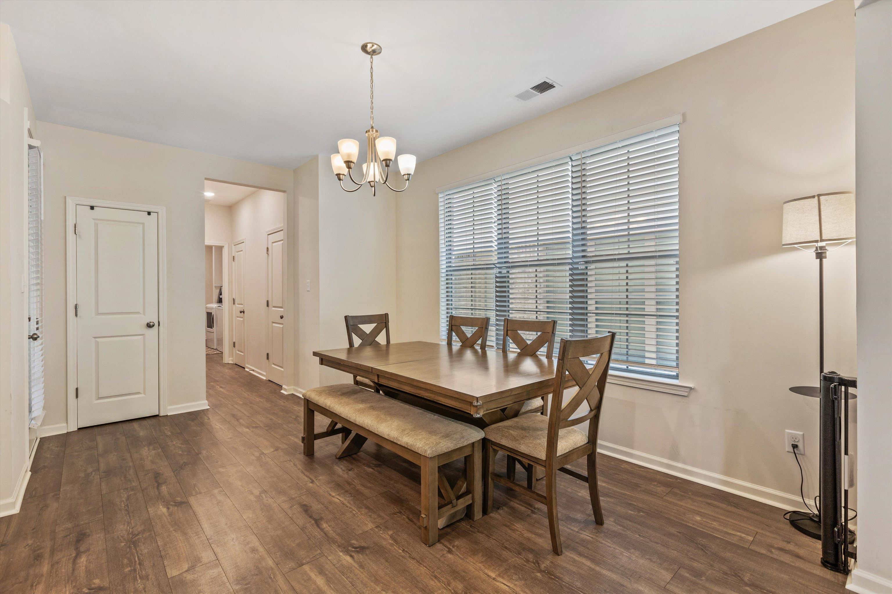 10139 Macon Road Cordova, TN 38018 - Photo 8 of 31 Dining area featuring wood-finish flooring, a window with horizontal blinds, and a multi-light chandelier