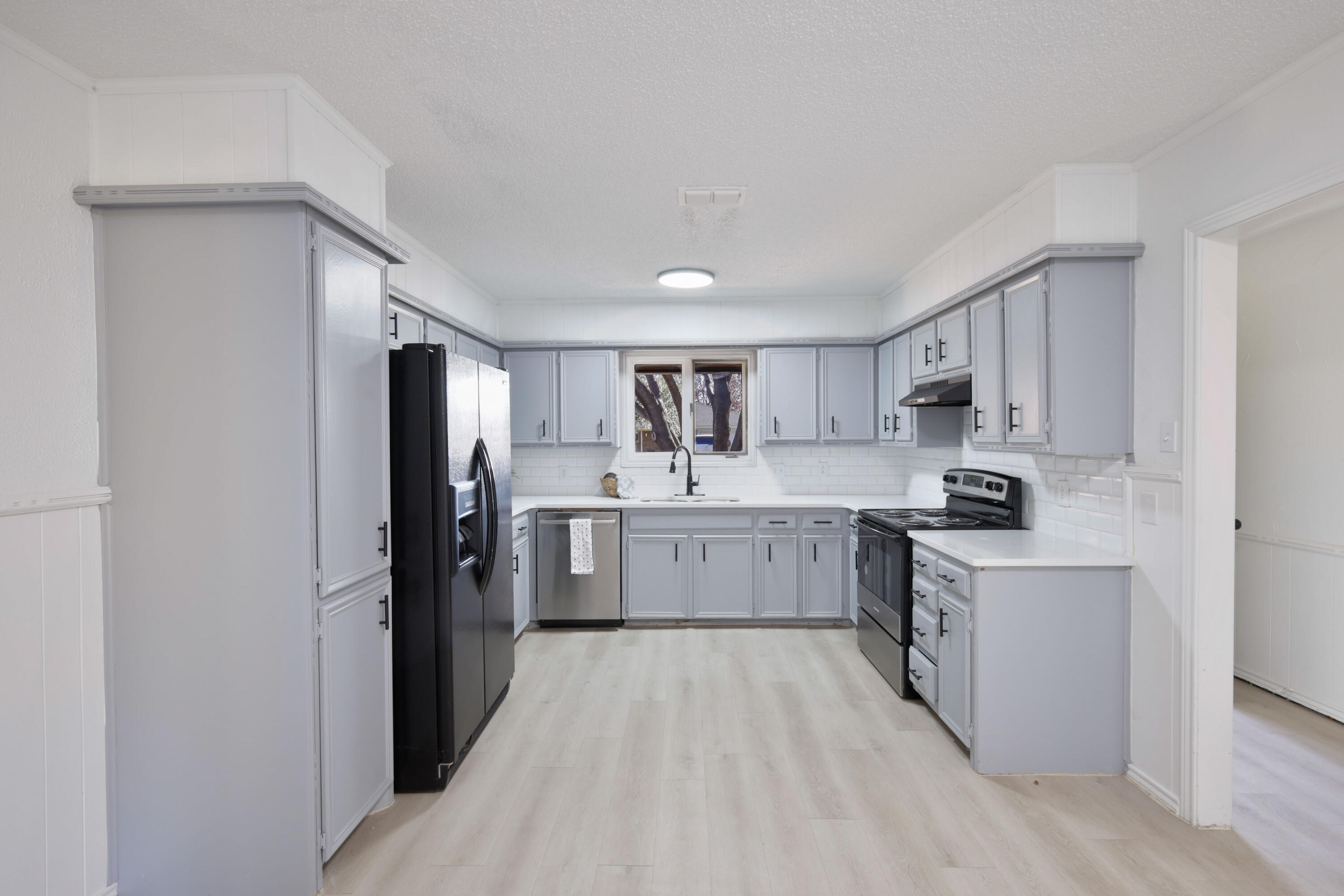 5104 73rd Street Lubbock, TX 79424 - Photo 5 of 20 a kitchen with a refrigerator a sink dishwasher with a oven and cabinets