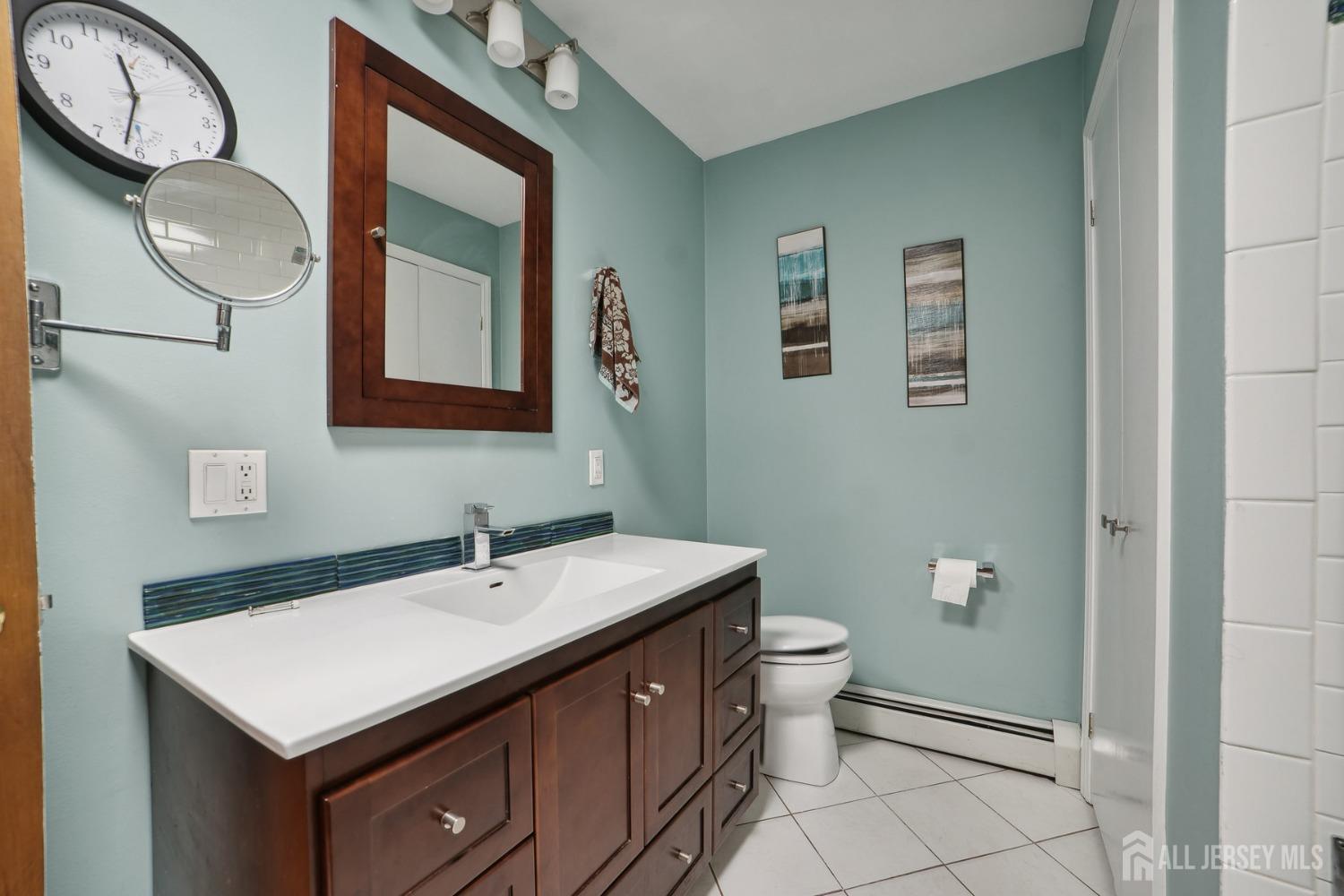 442 Garretson Road Bridgewater, NJ 08807 - Photo 14 of 29 a bathroom with a toilet sink vanity and mirror