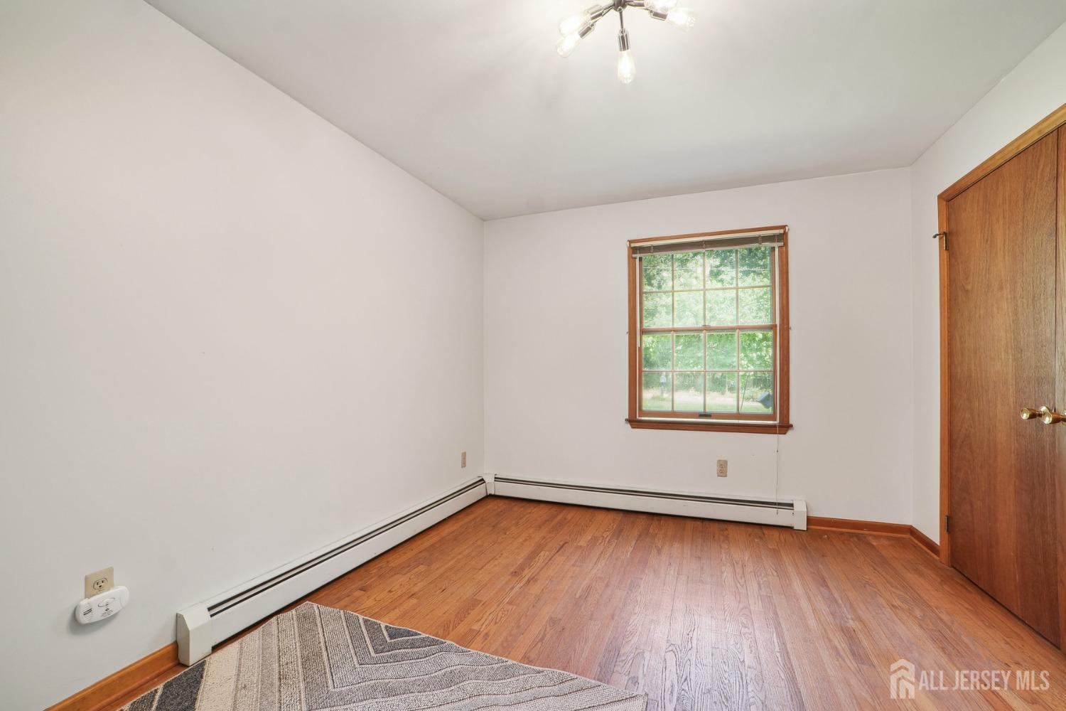 442 Garretson Road Bridgewater, NJ 08807 - Photo 19 of 29 an empty room with wooden floor and windows